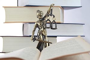a lawyer statue with an open book next to it that contains good email marketing practices for law firms