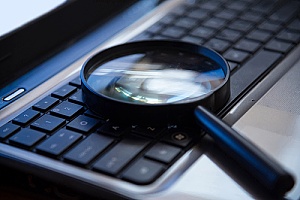 a magnifying glass on a keyboard representing search terms