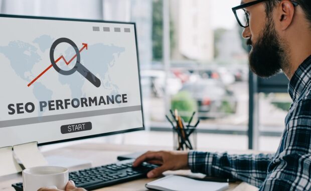 developer working with computer with performance on screen at workplace