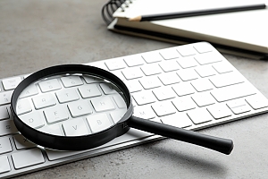 magnifying glass on keyboard to represent Ahrefs Keyword research