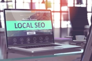 modern workplace with laptop showing landing page with local seo