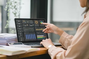 female analyst utilizes a computer and a dashboard for business data analyze and a data management system with KPI