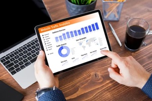 man viewing website traffic analytics data on tablet computer