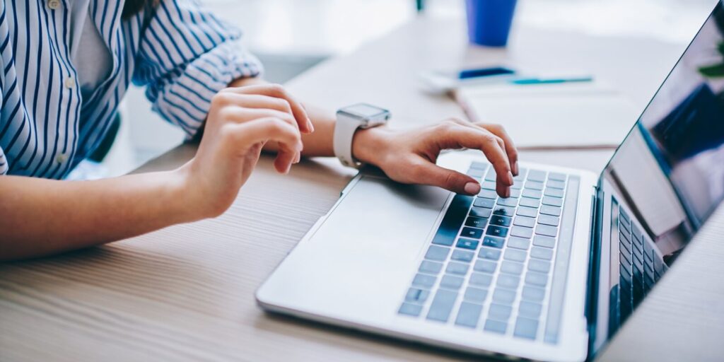 image of female hands searching web information during social networking via modern laptop computer